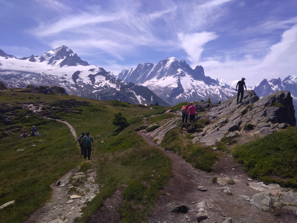 View of snowy mountains with people on rocks in the foreground
