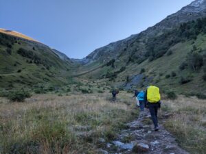 Three hikers approaching a col on the TMB West